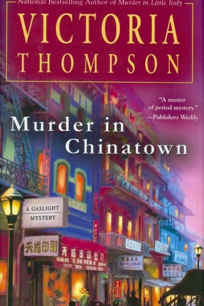 Murder in Chinatown by Victoria Thompson book cover shows a street in Chinatown in New York City at dusk in the early 1900s. The sky is pink, and a gas street lamp is lit in the foreground.