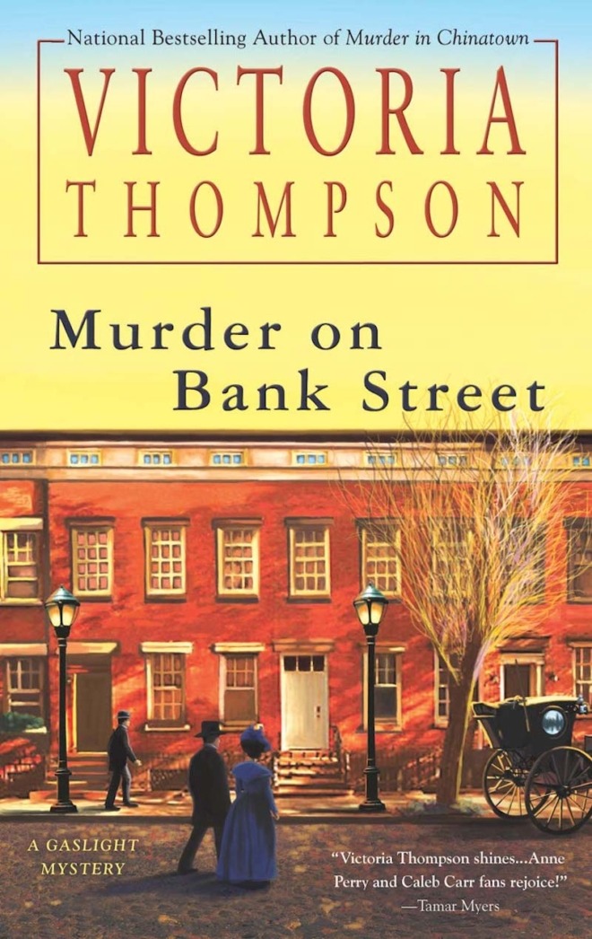 Murder on Bank Street by Victoria Thompson book cover shows a row of New York City brownstones in the early 1900s. It's late in the afternoon and the sky is yellow. A man and woman cross the street toward the buildings, another man walks on the sidewalk, and the back of a carriage can be seen in the street. Gas street lamps are lit.
