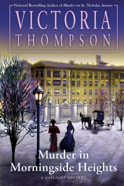 Murder in Morningside Heights by Victoria Thompson book cover shows a New York City building behind an ornate gate in the early 1900s. There is snow on the ground, it's dusk, and a gas street light is lit. Two women and a horse and carriage head toward the building.