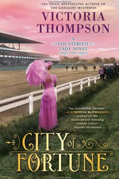 City of Fortune by Victoria Thompson book cover shows a woman in early 1900s clothing, a pink dress with a pink parasol, strolls by a horse race at dusk. The sky is pink.