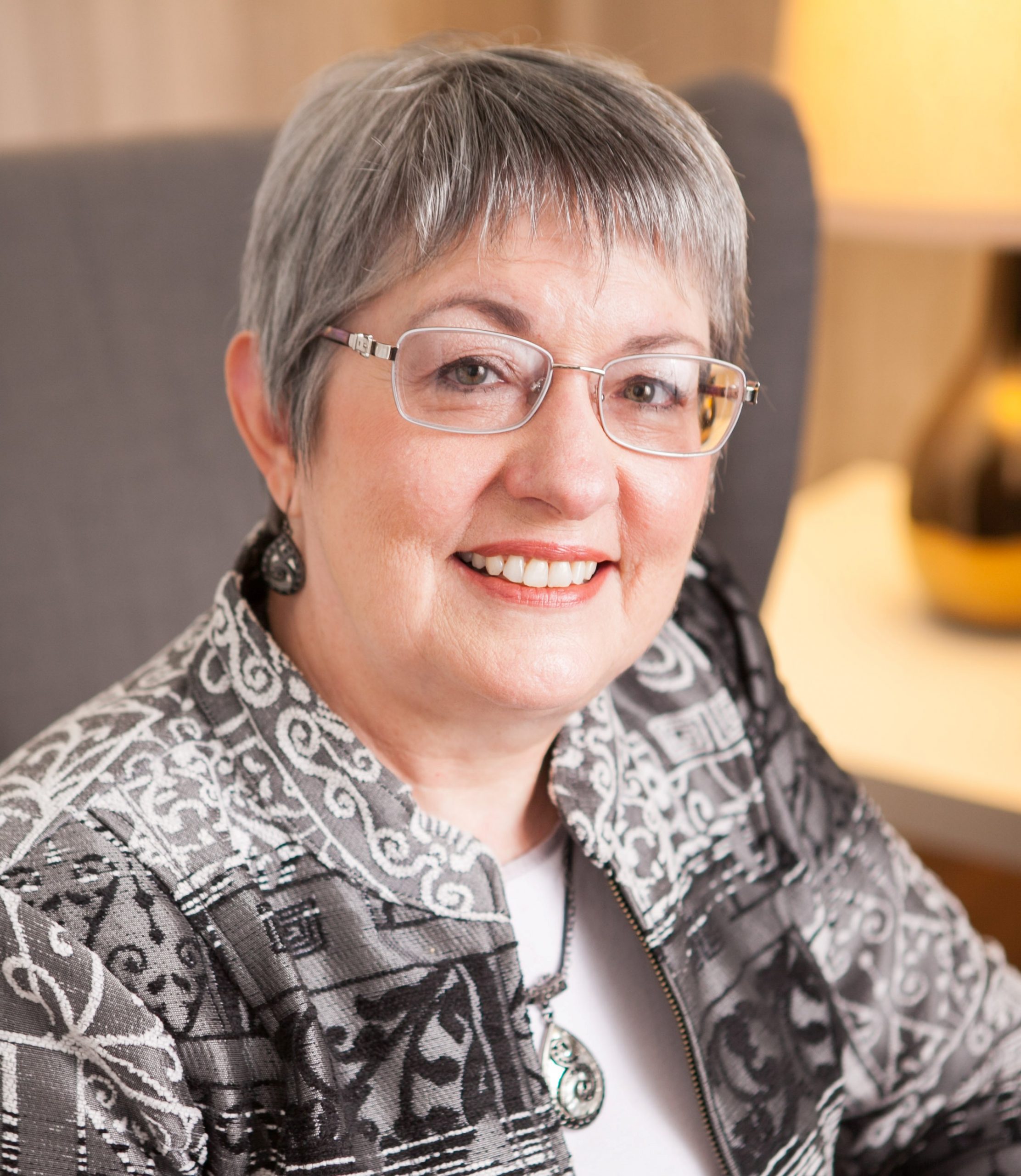 photo of Victoria Thompson, a middle-aged woman with short salt and pepper hair. She's wearinig glasses and smiling.